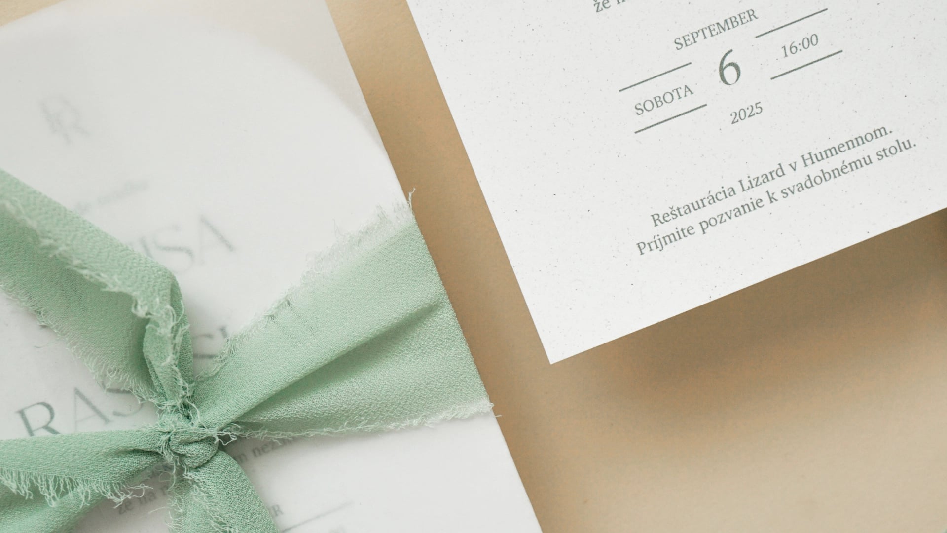 Svadobné oznámenie s jemnou zelenou mašľou a elegantným papierom