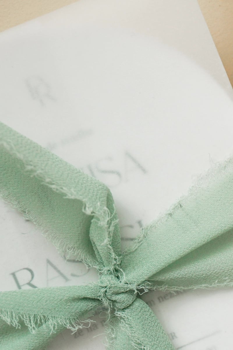 Svadobné oznámenie s jemnou zelenou mašľou a elegantným papierom